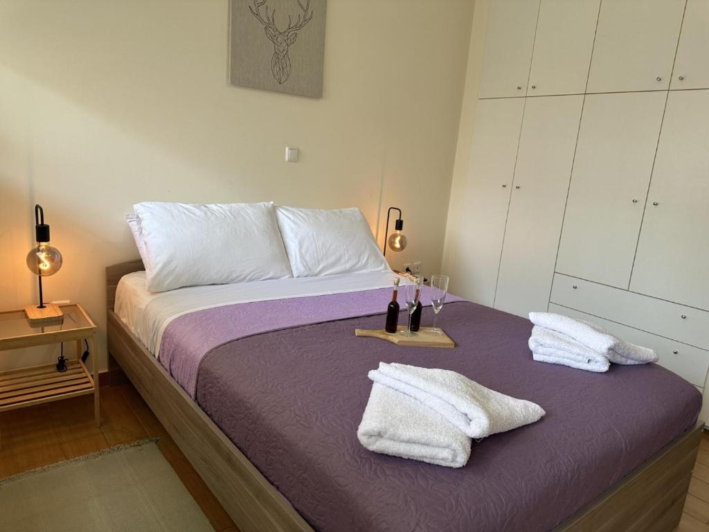 a bedroom with a bed with towels and wine bottles on it at LY Deluxe Apartment Athens in Athens