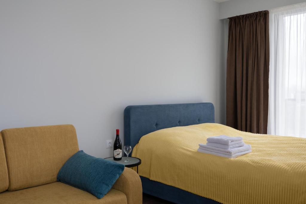 ein Schlafzimmer mit einem Bett und einem Stuhl neben einem Fenster in der Unterkunft Gudauri Ski Resort - Twins Mountain View Apartments in Gudauri