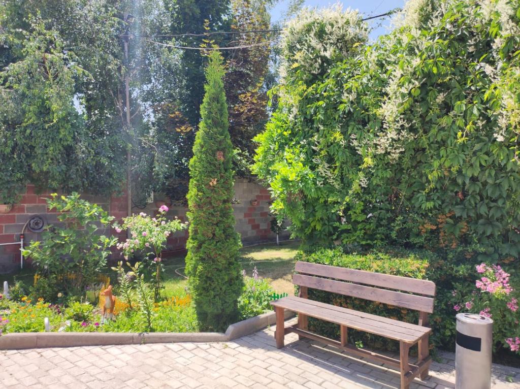 un banco de madera sentado en medio de un jardín en Уютный Дворик Чолпон-Ата, en Cholpon-Ata