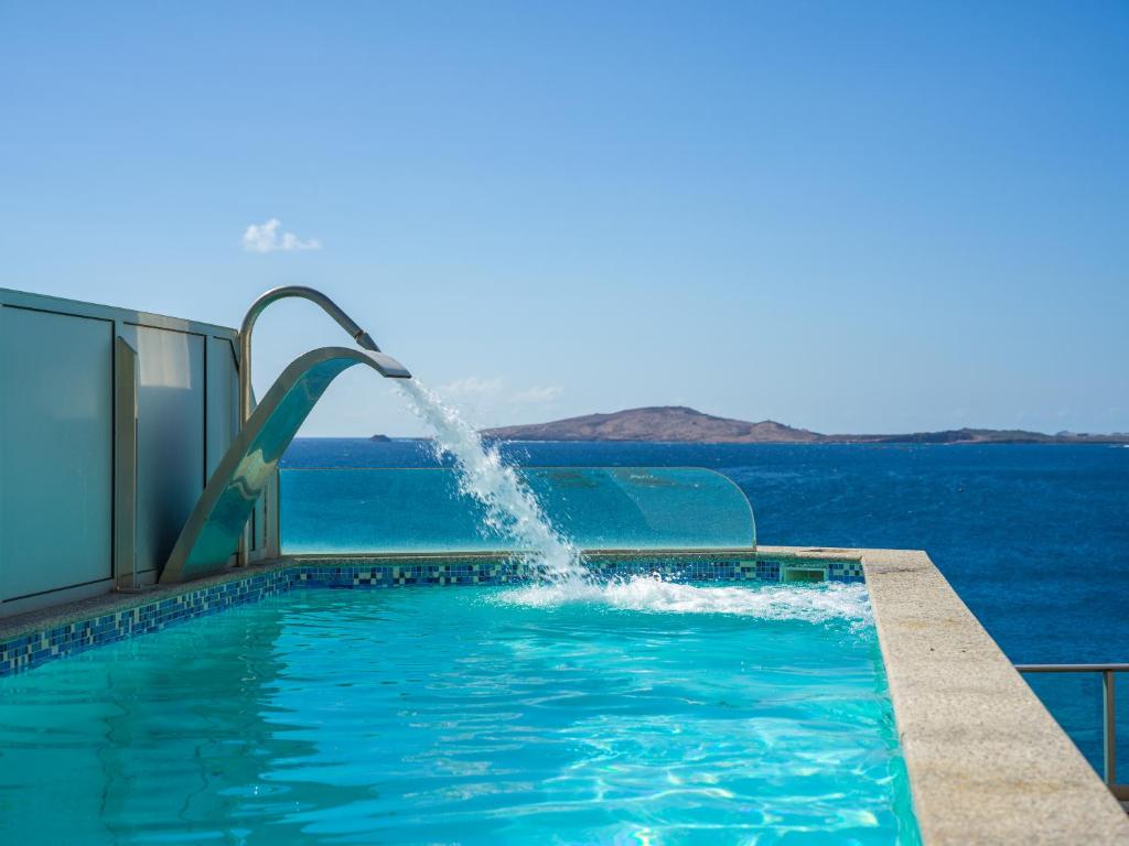 ein Tauchbecken mit Wasser, das in den Ozean schießt in der Unterkunft Penthouse with Private Swimming Pool in Melenara