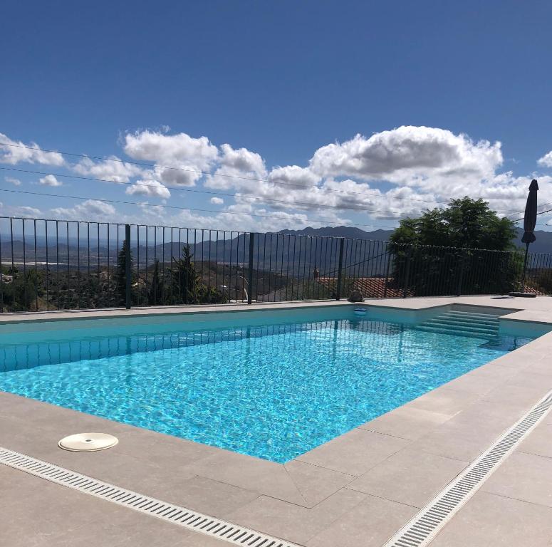 uma piscina com água azul em frente a uma cerca em Casa Miramar, with private pool, jacuzzi and stunning views em Bédar