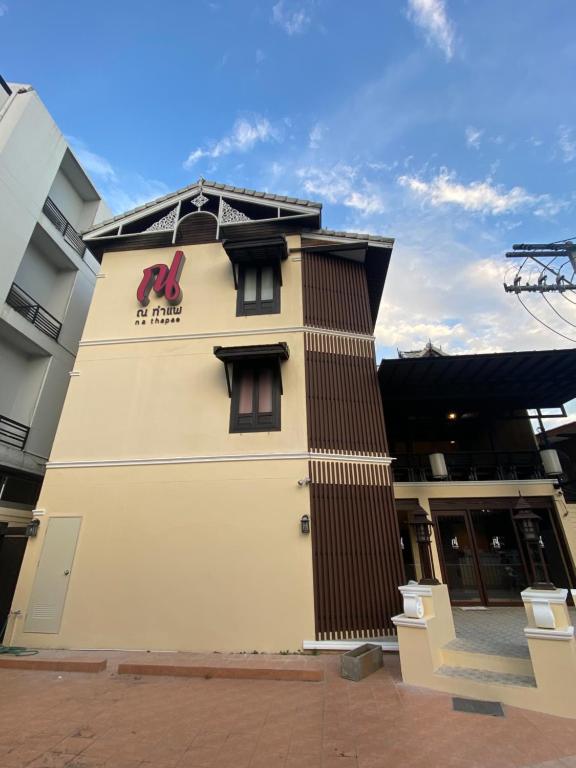 a building with a sign on the side of it at Na Thapae Chiangmai Hotel in Chiang Mai