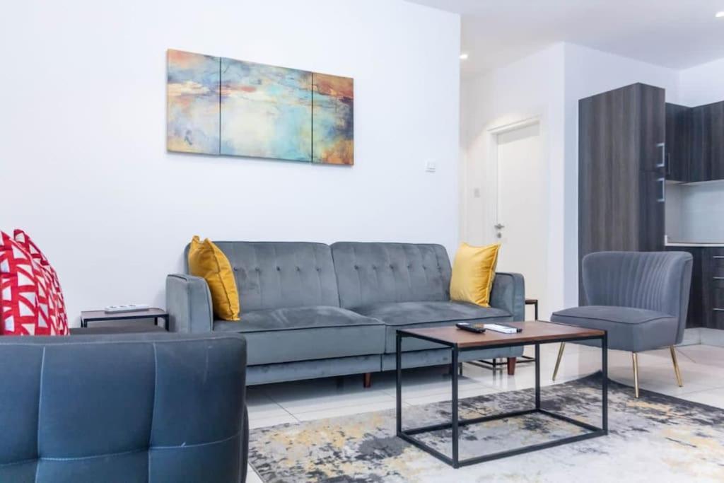 un salon avec un canapé et une table dans l'établissement Best 1 Bedroom Plus Guest Toilet @Embassy Gardens, à Cantonments