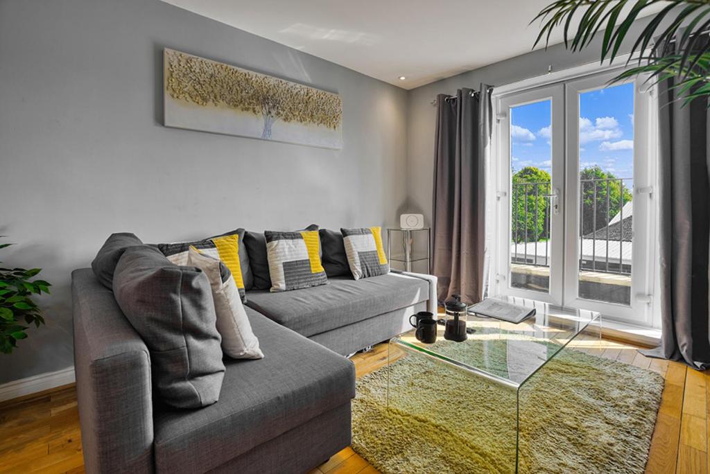 a living room with a couch and a glass table at Sandy Lane Apartment in Skelmersdale