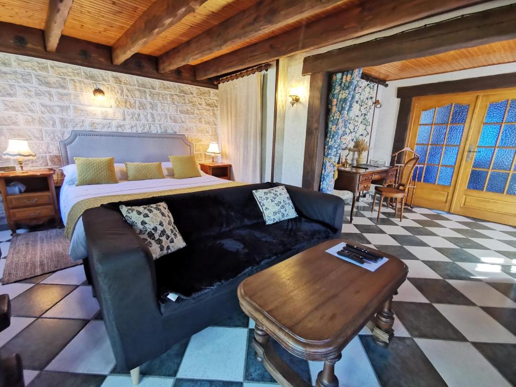 a living room with a bed and a couch and a table at Le gîte du Brouage in Chauny