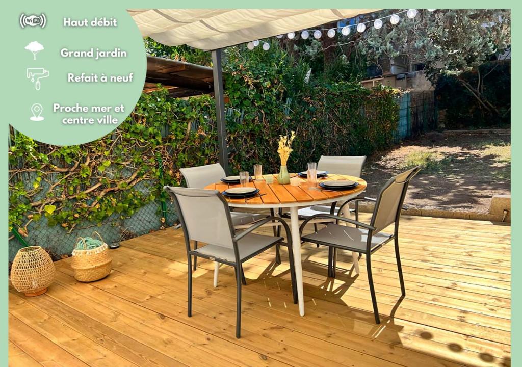 une table en bois avec des chaises et un parasol sur une terrasse dans l'établissement Entre mer et centre-ville: Charmant et lumineux T1, à Saint-Raphaël
