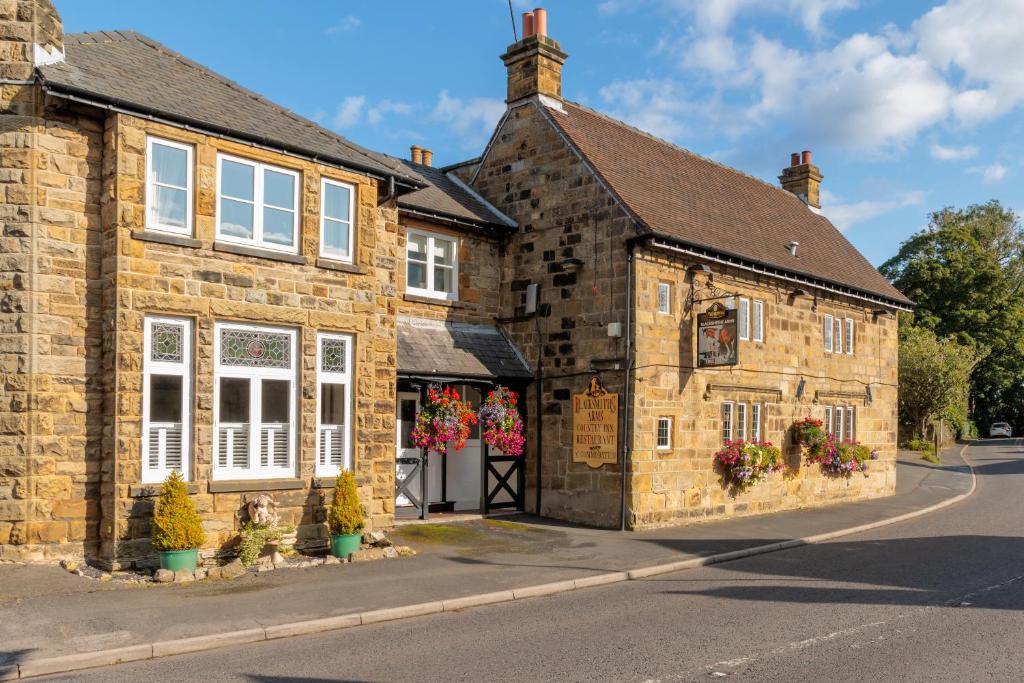 an old stone building with flowers in front of it at Blacksmiths Arms Inn in Scarborough