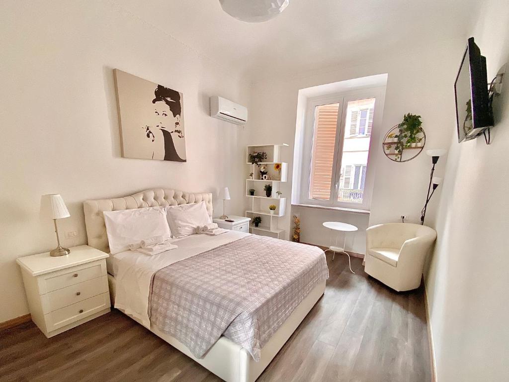 een witte slaapkamer met een bed en een stoel bij Nido della Regina in Turijn