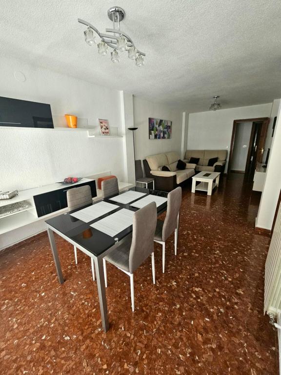 sala de estar con mesa, sillas y sofá en Piso Granada 3 dormitorios y parking privado, en Granada