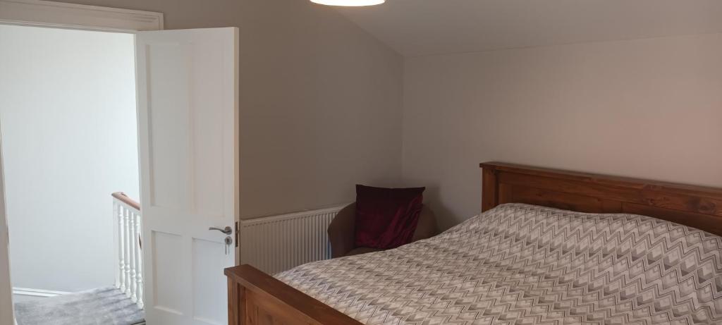 布瑞的住宿－Eglinton Road - Super King - Ensuite，一间卧室配有一张带木制床头板的床