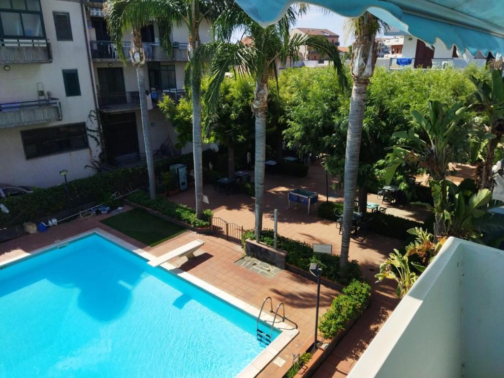 una vista sulla piscina di un hotel con palme di Etna Beach Home a Mascali