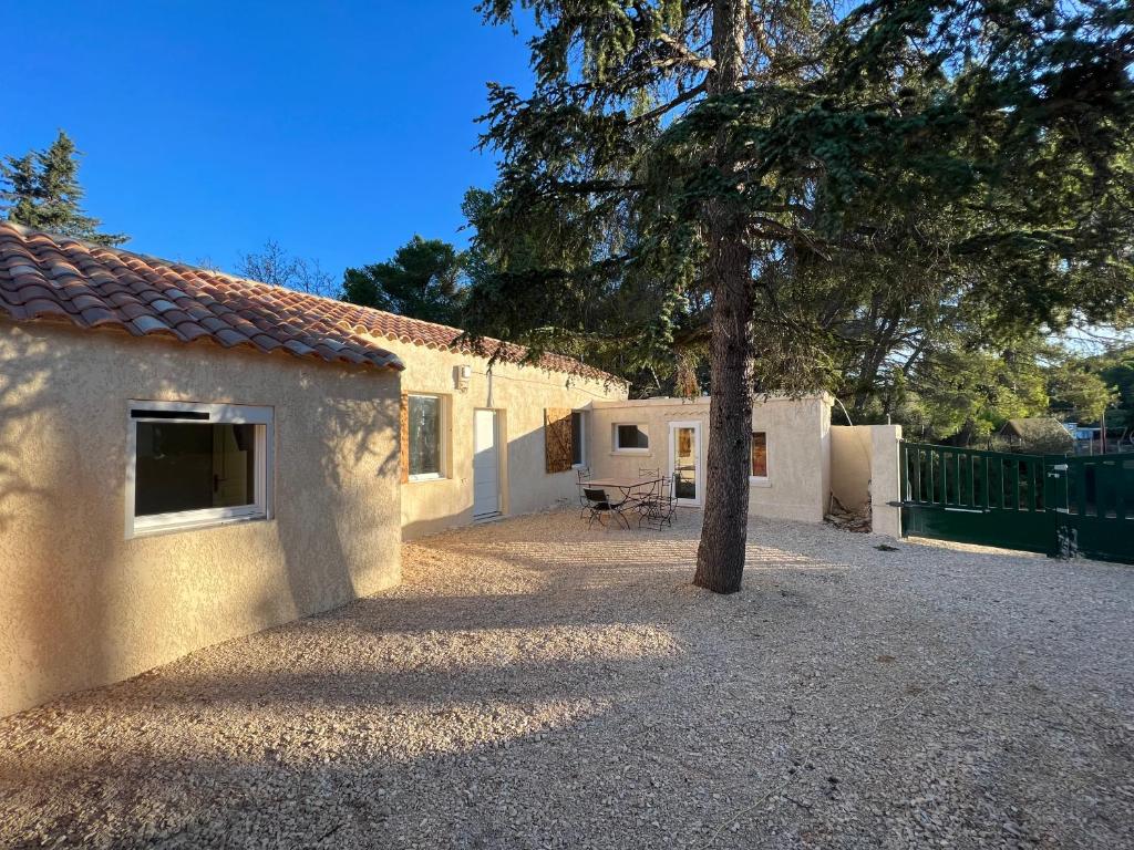 a building with a tree in the middle of a driveway at Jolie maison individuelle 45m2 in Saint-Mitre-les-Remparts