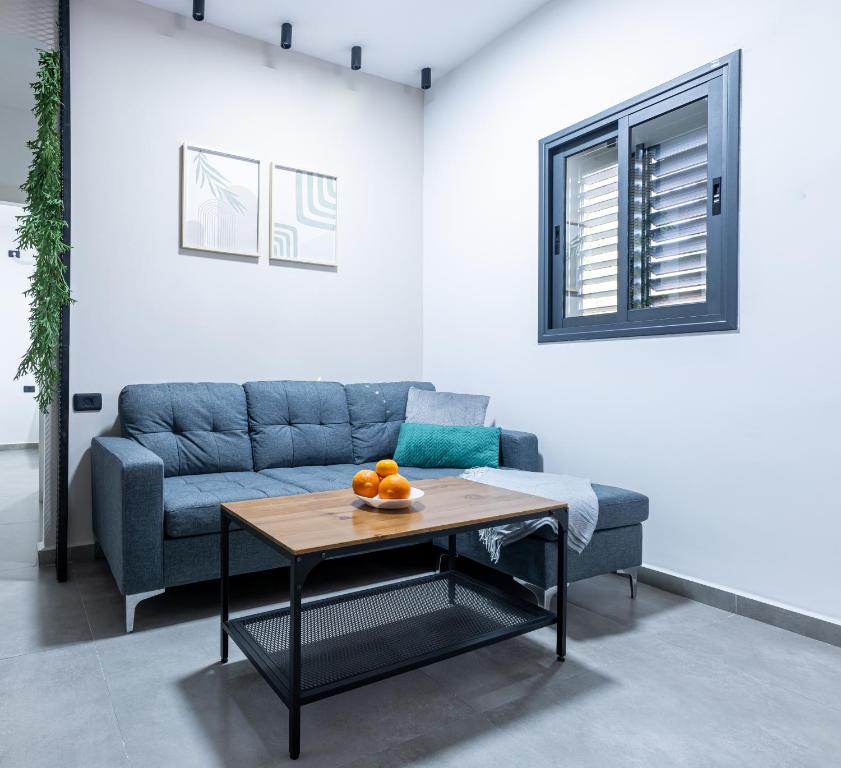 een woonkamer met een blauwe bank en een tafel bij Luxury Central Old Town Apartment in Beer Sheva