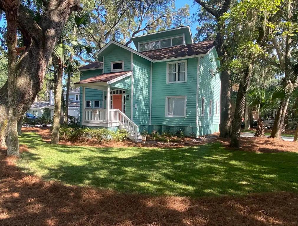 a green house with trees in front of it at 1 Egret Street N Forest Beach in Hilton Head Island