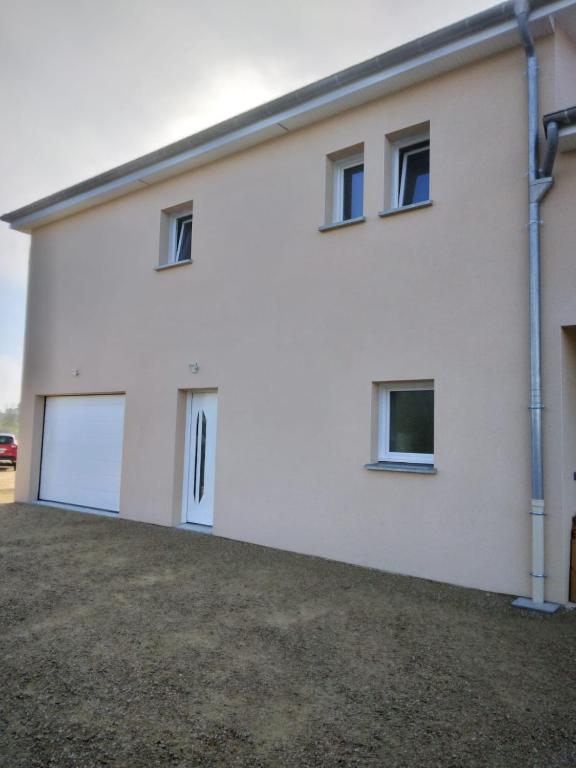 a white building with windows and a driveway at Chez Nelly in Versaugues