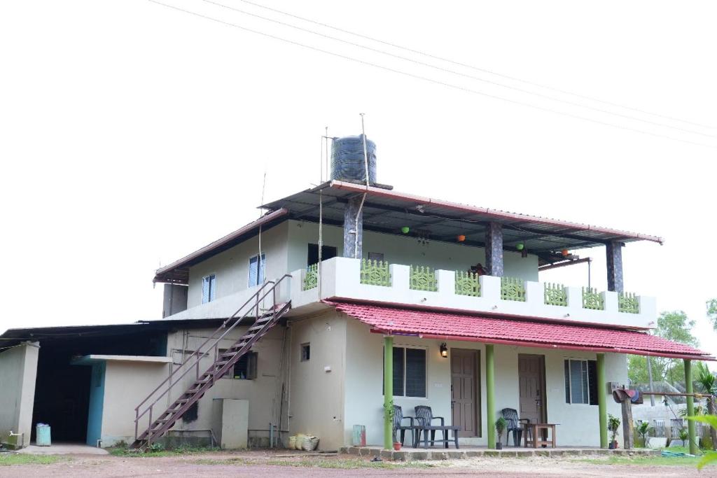 een gebouw met een balkon en een trap erop bij Malgudi Homestay in Someshwar