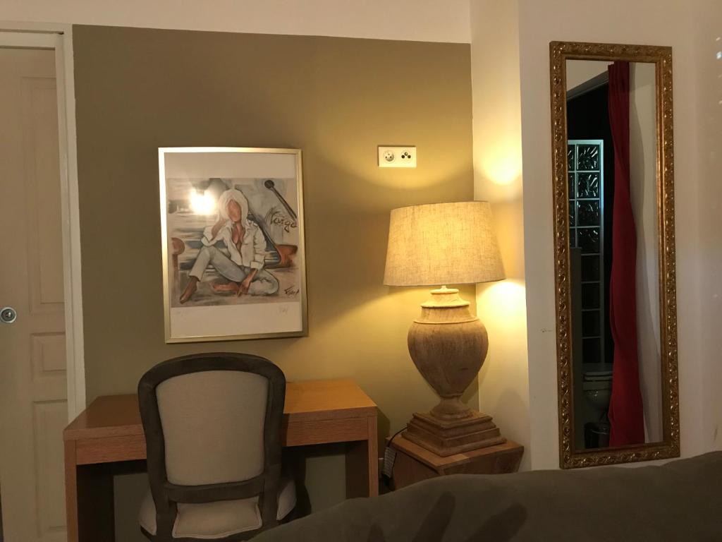 1 dormitorio con escritorio, silla y espejo en VILLA SANTONI, en Grosseto-Prugna