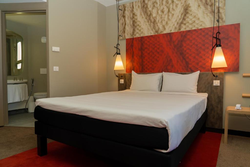 a bedroom with a large bed with two white pillows at ibis Alger Aéroport in Alger