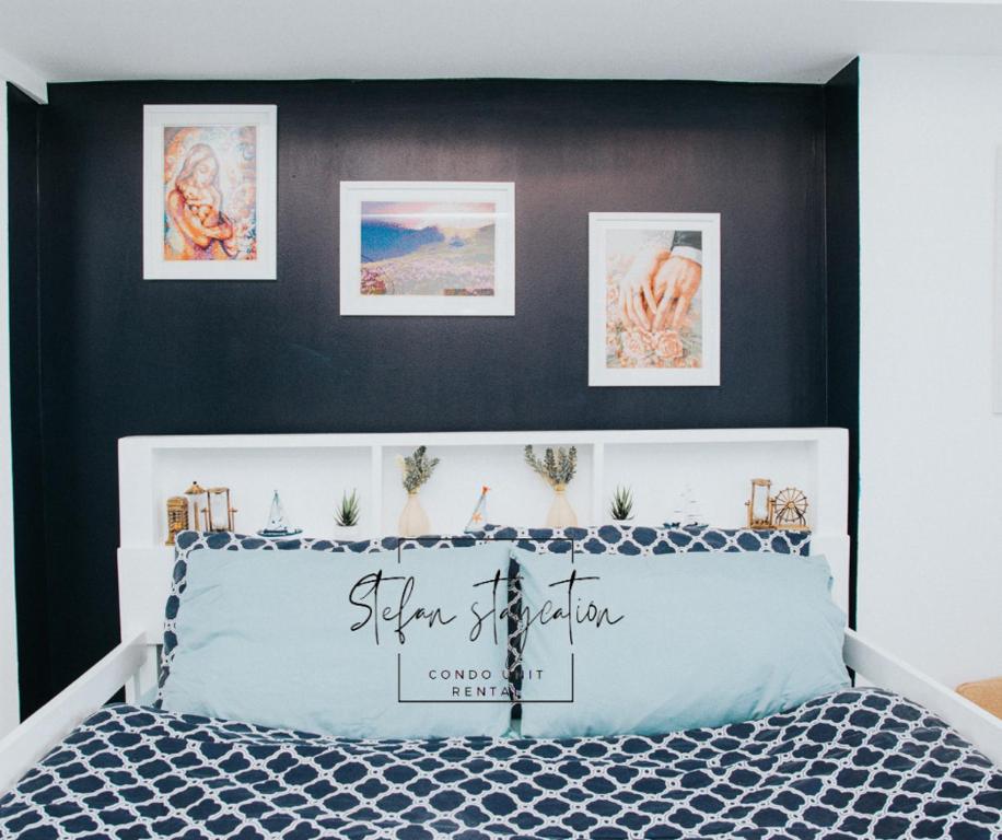 Stefan Staycation @ Azure North في سان فيرناندو: غرفة نوم بسرير ازرق وبجدار اسود