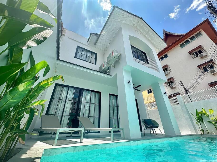 une maison avec une piscine en face de celle-ci dans l'établissement House no.148 Patong pool villa, à Patong Beach