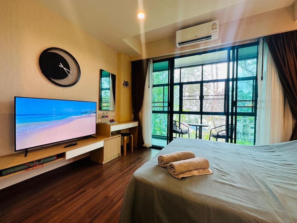 een slaapkamer met een flatscreen-tv en een bed bij Brand New Naithon Condo C411 in Nai Thon Beach