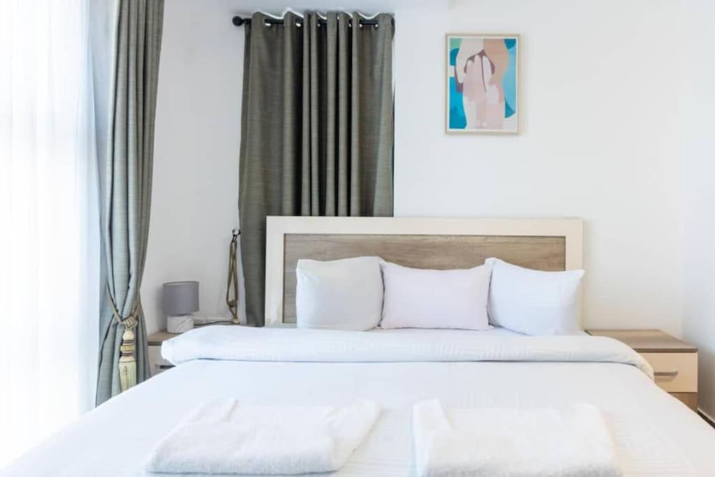 a bedroom with two beds with white sheets at Central 2 Bed Apartment in Cantonments