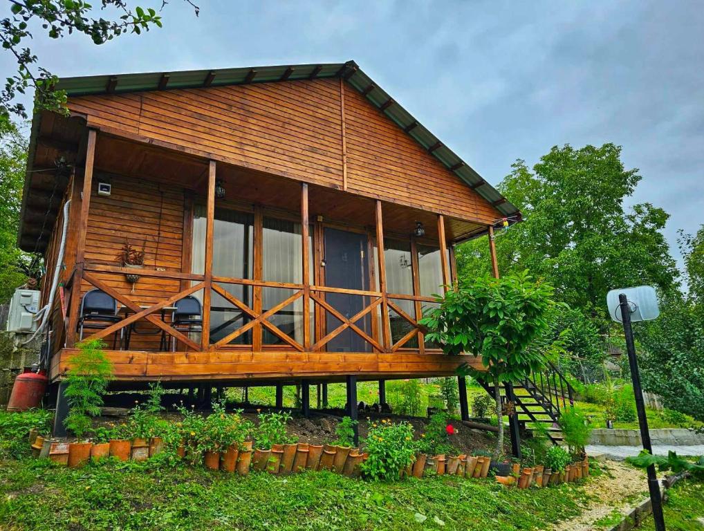 una casa de madera con ventanas y plantas en un patio en Racha Nanida, en Agara