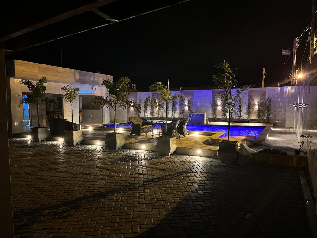 a patio with a table and benches at night at Casa em Acaú/ Pitimbu PB in Pitimbu