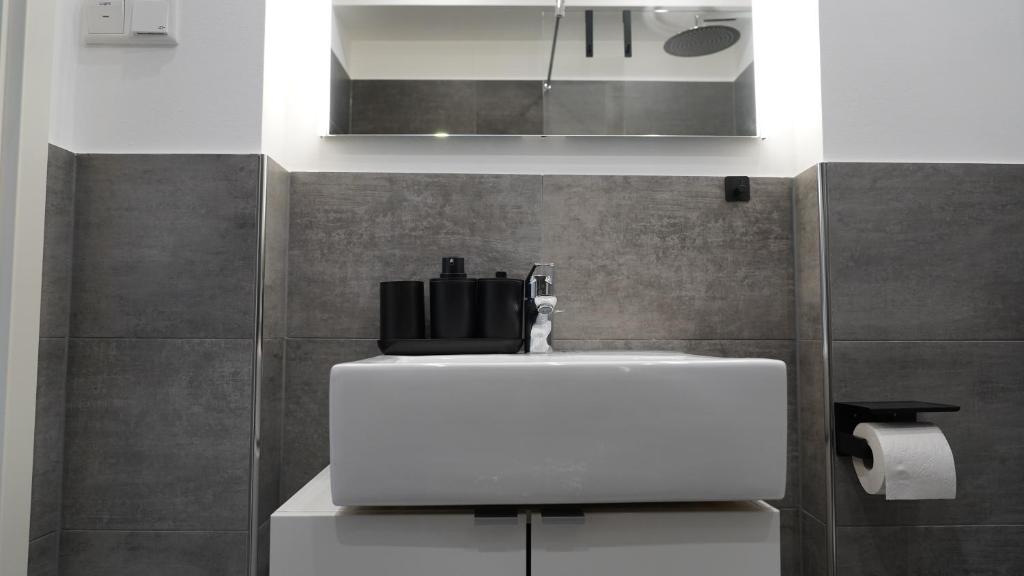 een badkamer met een witte wastafel en een spiegel bij Luxuriös & Sehr Zentral in Wuppertal in Wuppertal