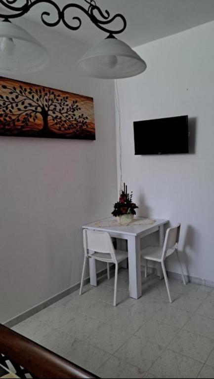 a white dining room table with two chairs and a television at La Foggia seaside paradise in Siculiana