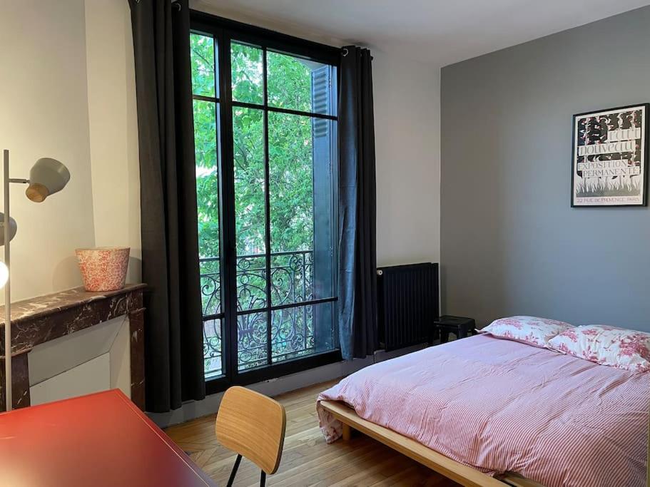 una camera con un letto e una grande finestra di Sèvres : joli 3 pièces a Sèvres