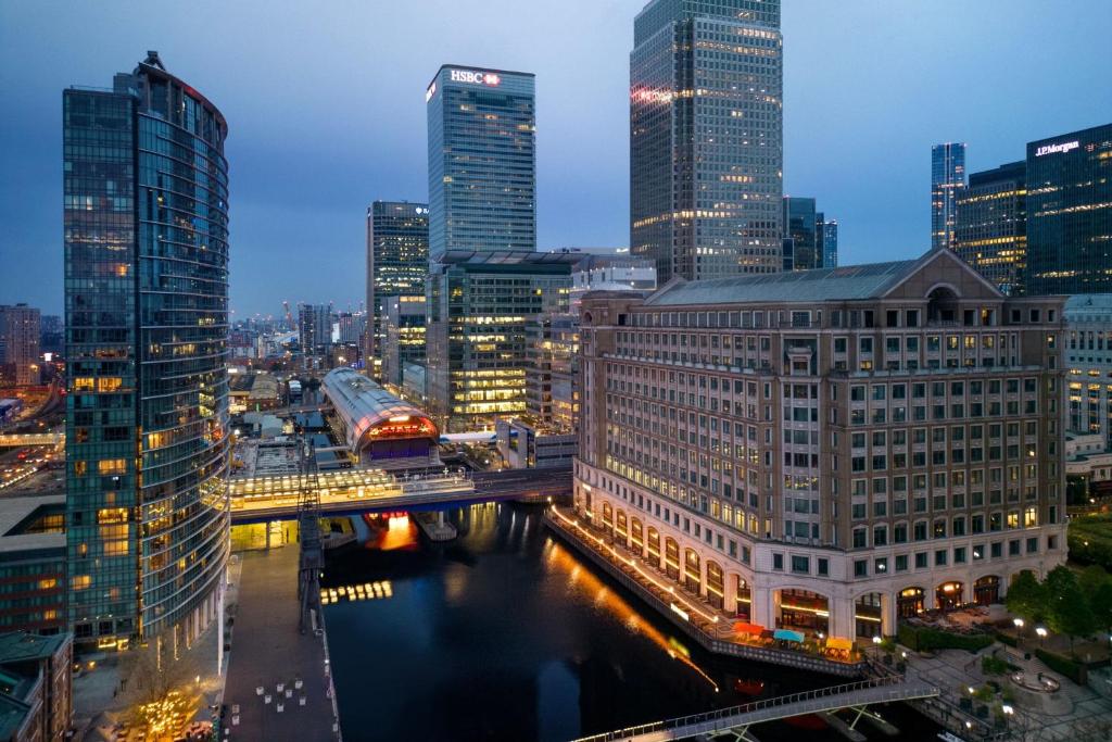 un perfil urbano por la noche con un tren en un puente en London Marriott Hotel Canary Wharf en Londres