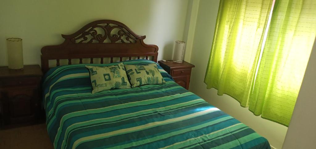 1 dormitorio con 1 cama con sábanas azules y verdes en Santa Teresita frente al Mar en Santa Teresita