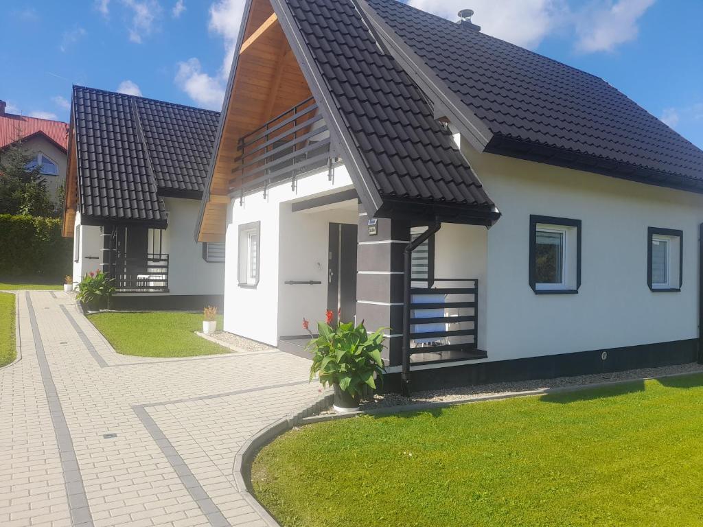 a white house with a black roof at Domki u Henia 330A in Wysowa-Zdrój