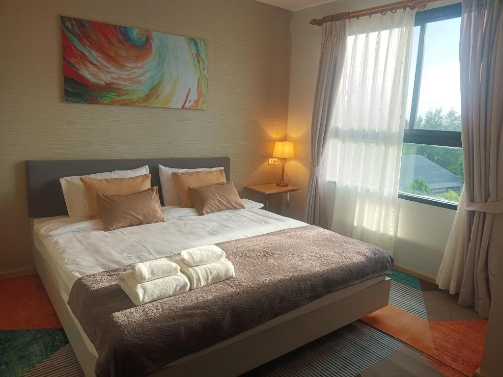 a bedroom with a bed with two towels on it at Bangtao - Laguna center, 1BR, Near Laguna Center in Ban Thalat Choeng Thale