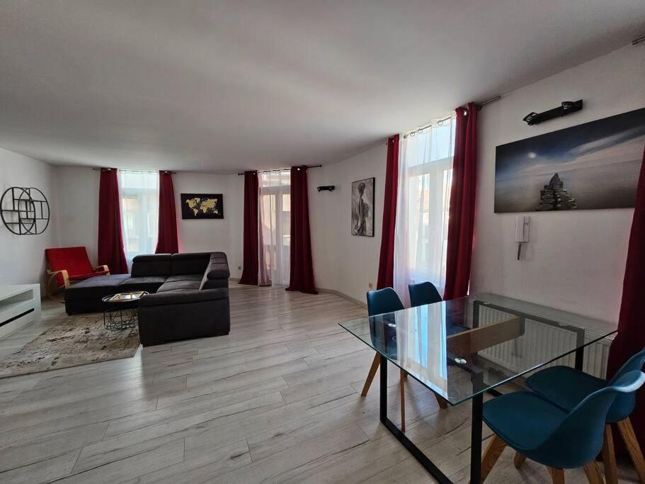 ein Wohnzimmer mit einem Glastisch und einem Sofa in der Unterkunft Grand Appartement cosy et lumineux in Mons