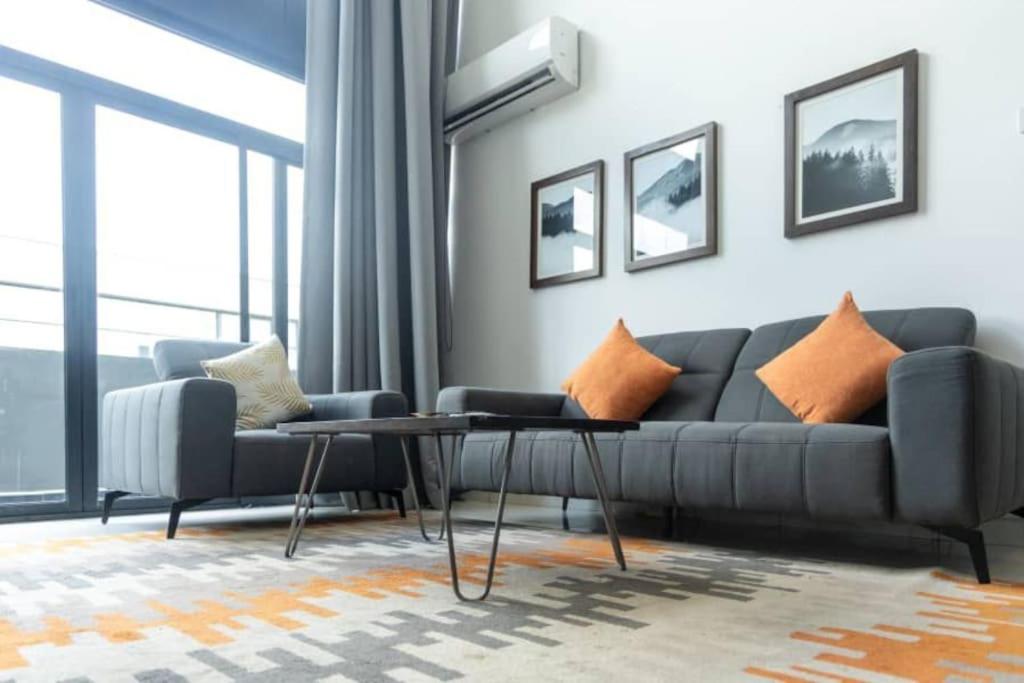 un soggiorno con un divano e un tavolo di Exec 2 Bed Loft@Embassy Gardens a Cantonments