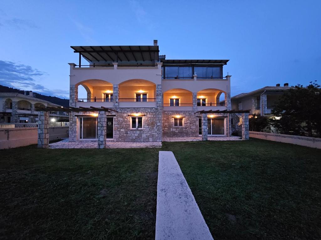 a large stone house with a yard at night at Viggas Relaxation Nafpaktos in Antirrio