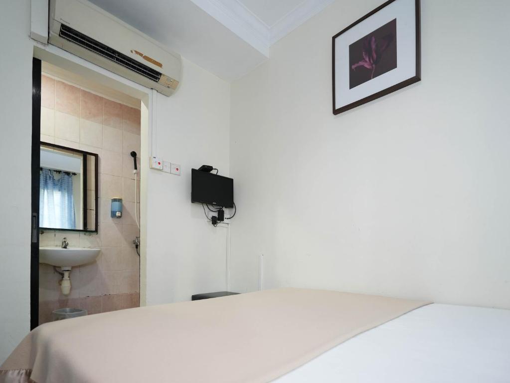 um quarto branco com uma cama e um lavatório em Amrise Hotel, Check in at 10PM, Check out at 9AM em Singapura