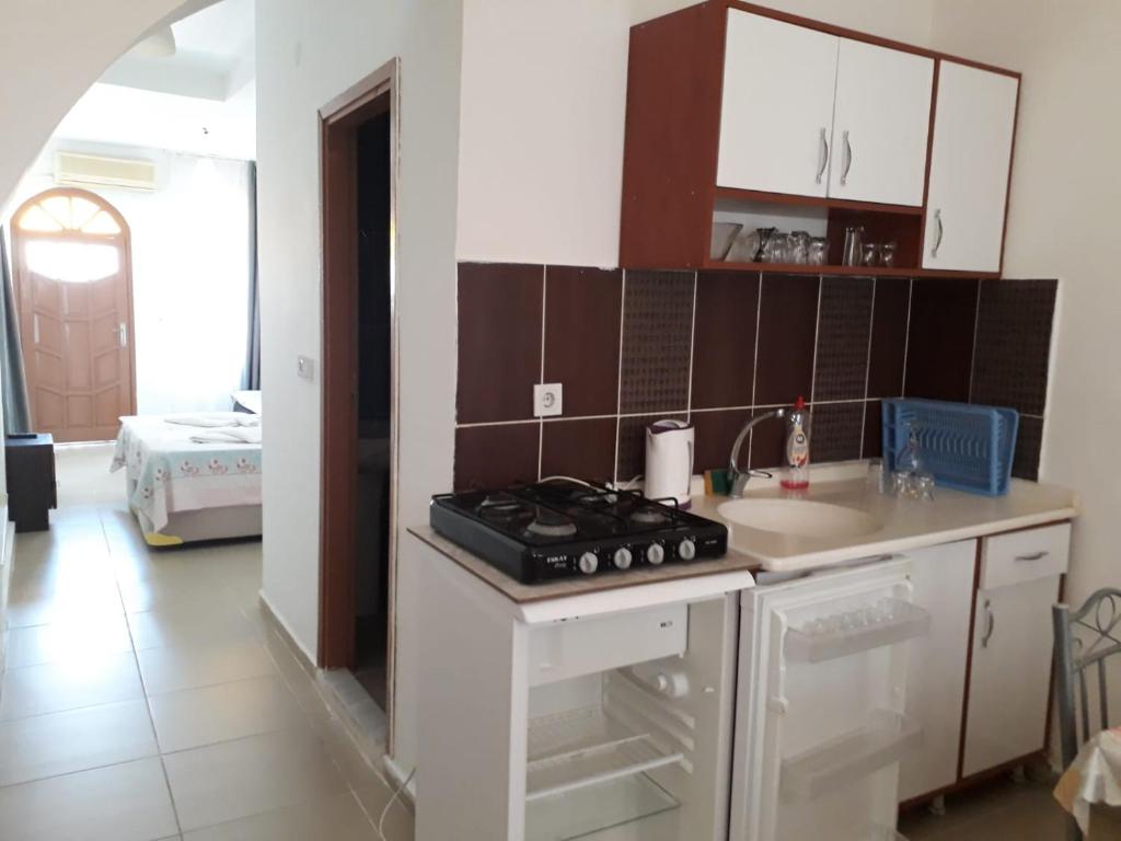 una cocina con estufa horno superior al lado de un fregadero en Sincer Otel, en Kusadasi