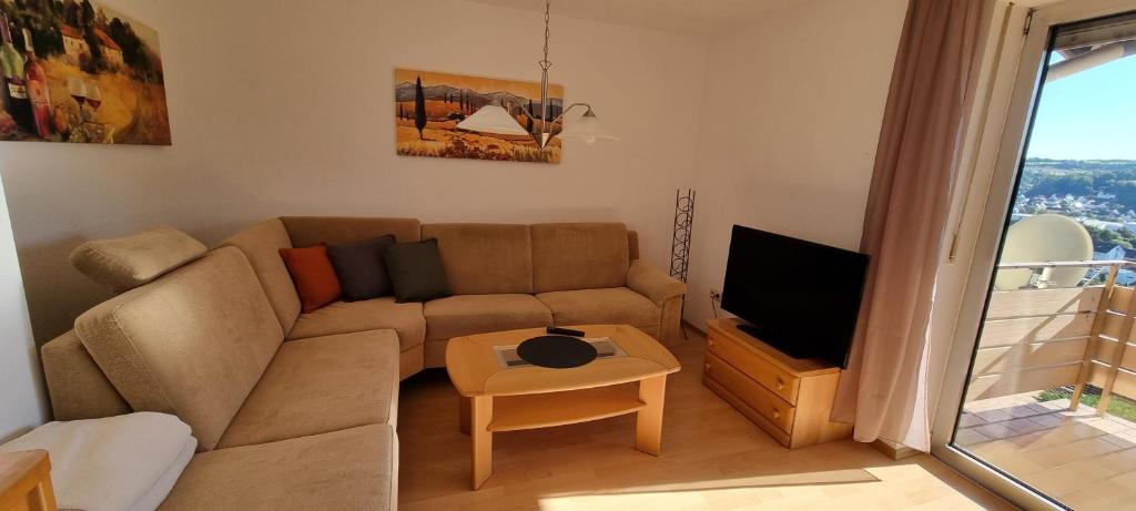 sala de estar con sofá y TV en Bellevue, en Zweibrücken