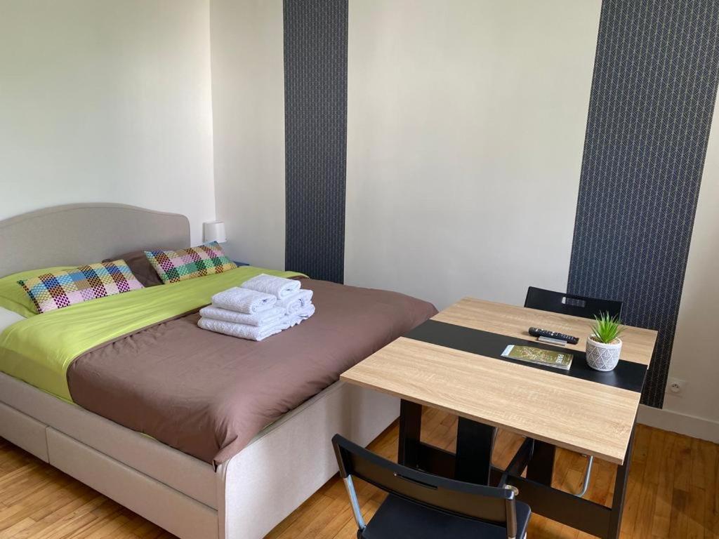 a small bedroom with a bed and a table at Studio de charme in Pantin