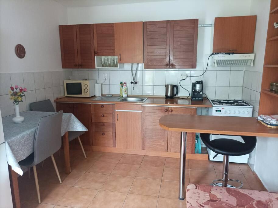 eine kleine Küche mit Holzschränken und einem Tisch in der Unterkunft Ubytovanie Hrabiny in Sučany