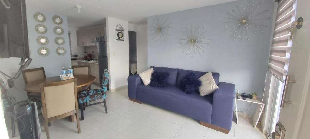 uma sala de estar com um sofá azul e uma mesa em Departamento-Poliforum Feria Estadio Zona Piel. em León