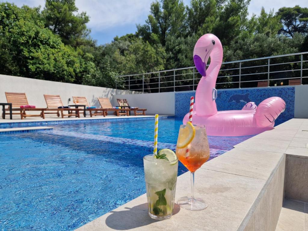 un par de bebidas sentadas en una cornisa junto a una piscina en Villa Olivila, en Dubrovnik