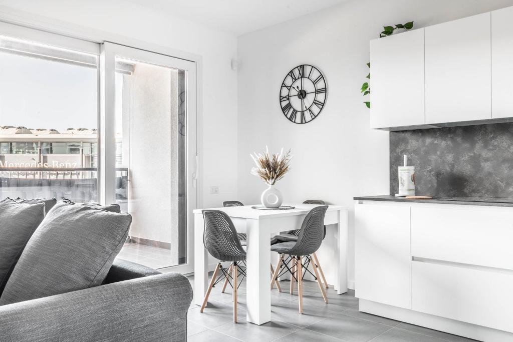 - un salon blanc avec une table et des chaises dans l'établissement Harmony House [Free Parking-Terrace-Netflix], à Milan