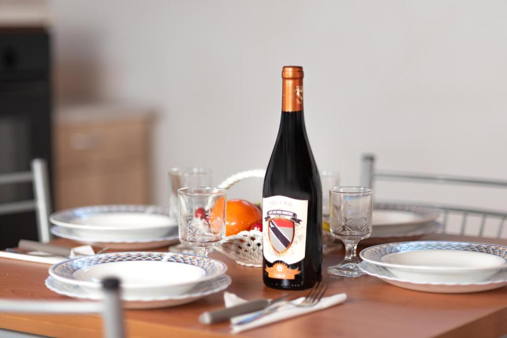 a bottle of wine sitting on a table with plates at Maison Château - Vista Castello di Saint Pierre in Saint-Pierre