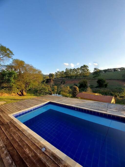 een zwembad met blauw water in een tuin bij Recanto do Sossego in Caxambu