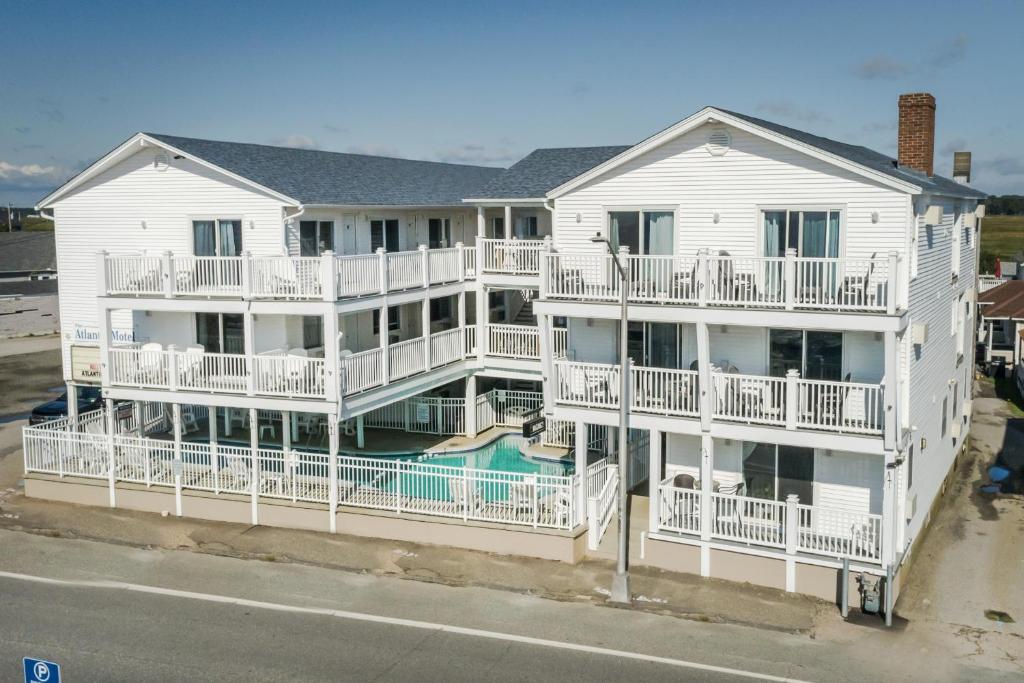 a large white apartment building with a swimming pool at The Atlantic Motel in Hampton