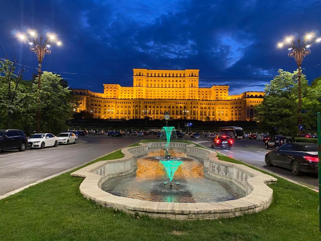 a large building with a fountain in the middle of a street at Unirii Home in Bucharest